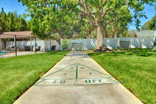 A backyard with a bocce court and a tree.